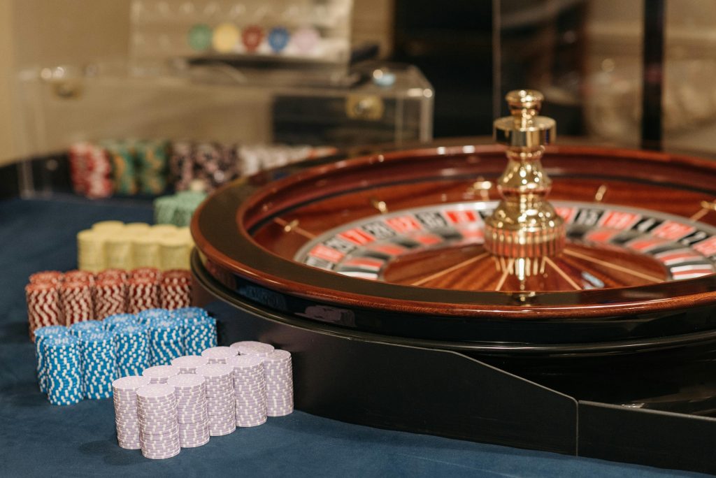 Colorful casino setting featuring a roulette wheel and stacked poker chips, highlighting gambling ambiance.